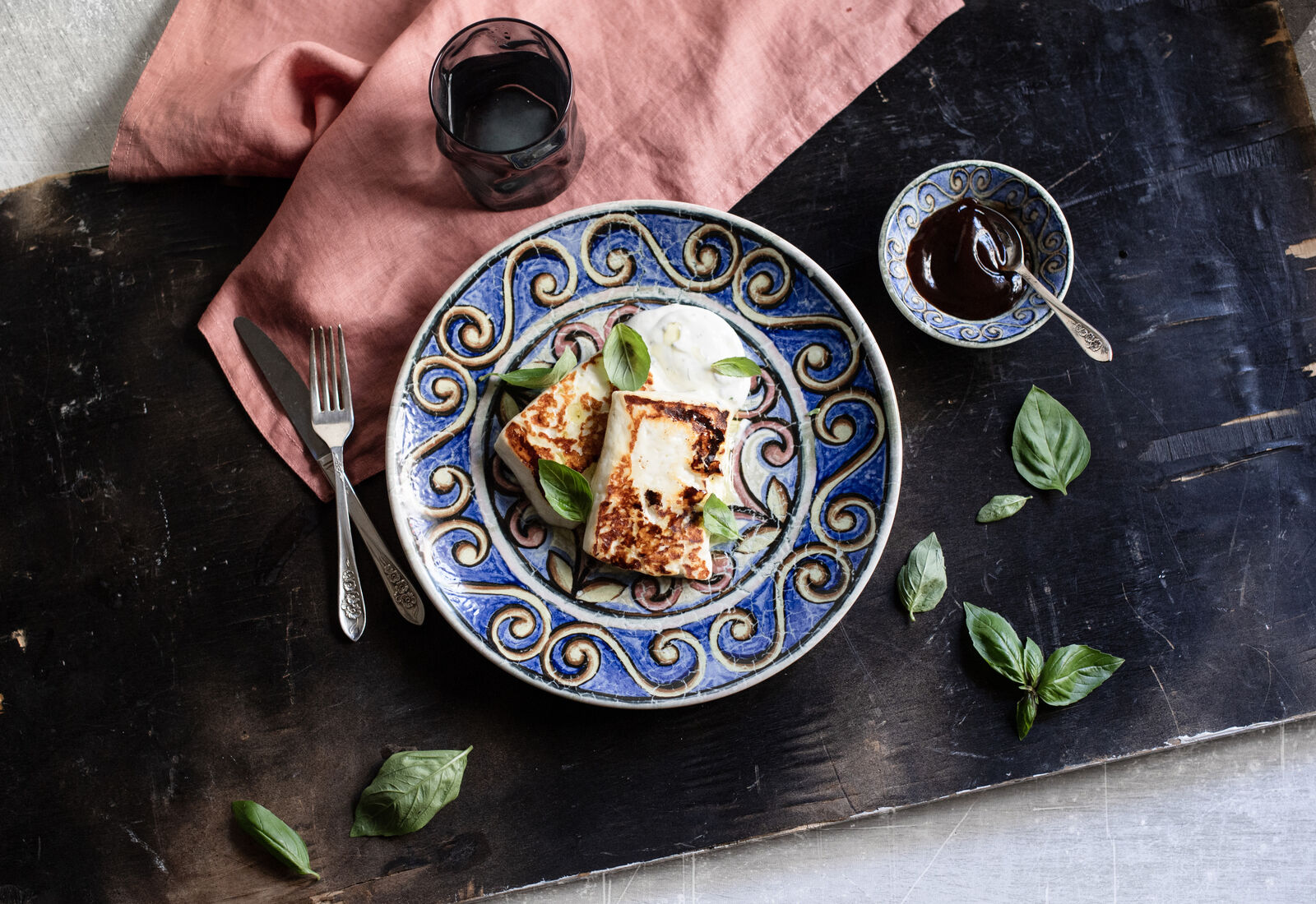 Eye-level view of a rustic wooden table set with colourful ceramic plates and cutlery